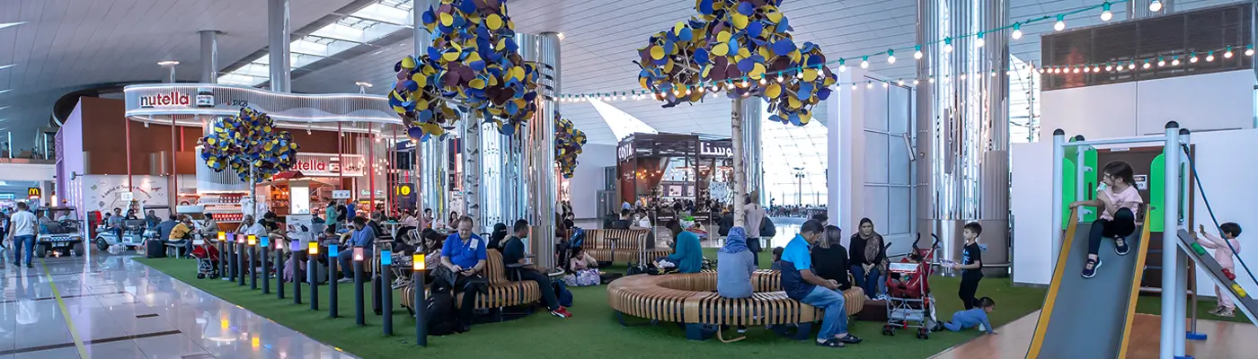 DXB Family Zone kids play area at Dubai Airport Terminal 3 — Arabian Desert-themed play zone with sand dune floor, climbing structures and children's interactive games in Concourse B between Gates B7 and B8